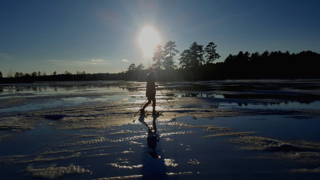 Tamra's friend, snowshoeing across a frozen pond late in the day