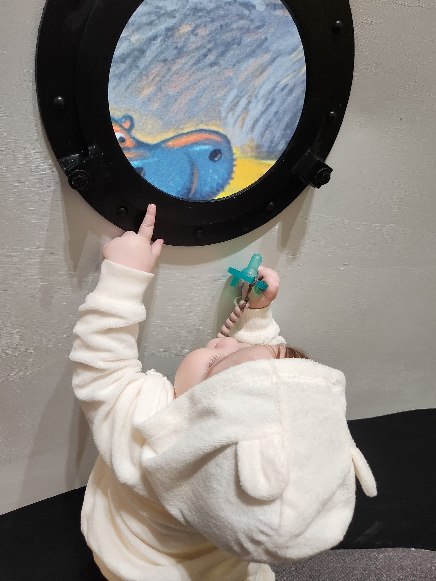 My granddaughter looking through a pretend porthole at the exhibit and seeing a hippo