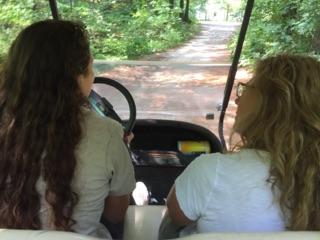 A gamekeeper and Tamra in a golf cart